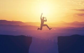 man-jumping-across-cliff